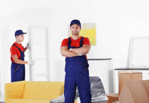 Professional movers carrying household items through a Finchley property